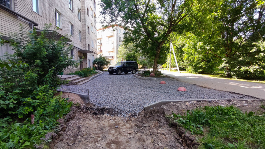 Двор жилого дома с парковкой на щебне