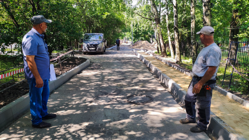 Два рабочих на участке благоустройства дворовой дороги