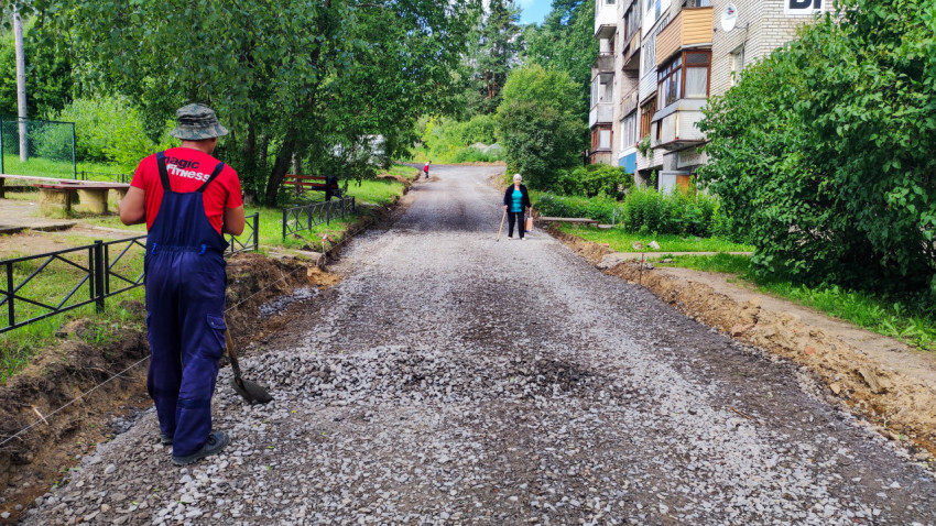 Рабочий и жители на щебёночной дороге во дворе