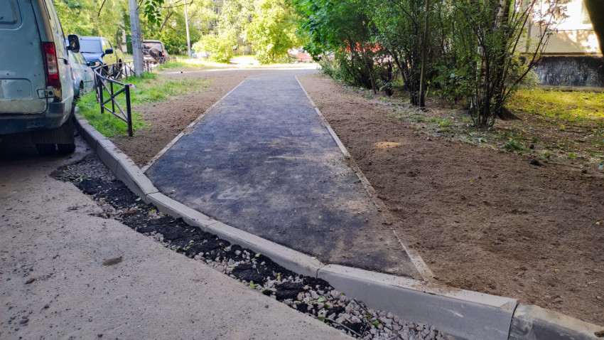 Асфальтовая дорожка у жилого дома с бордюрами