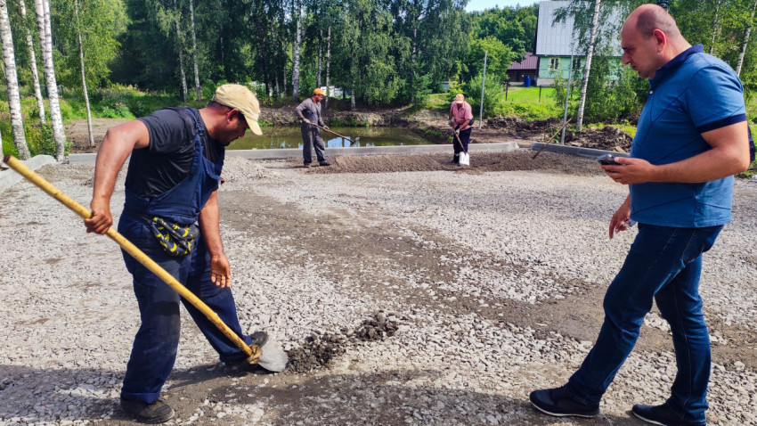 Рабочие выравнивают щебень на строительной площадке