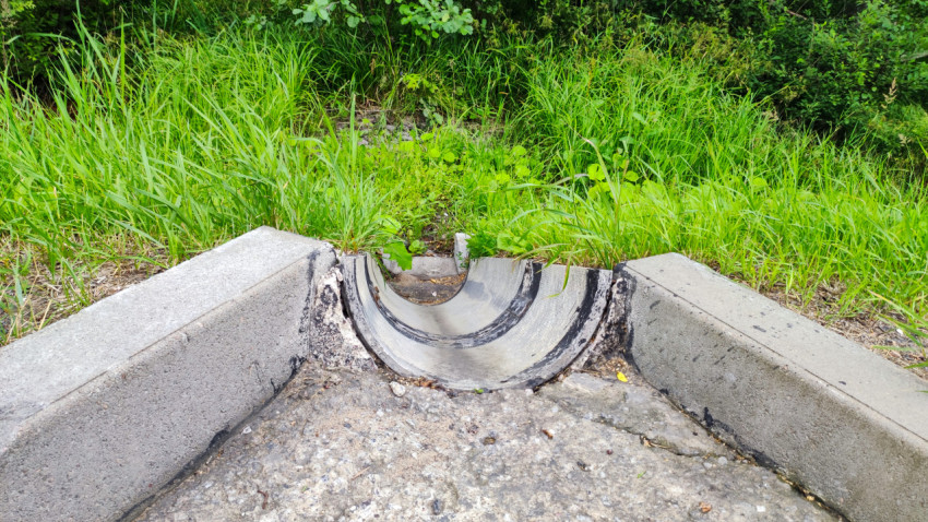 Водосточная бетонная лотковая конструкция у обочины дороги