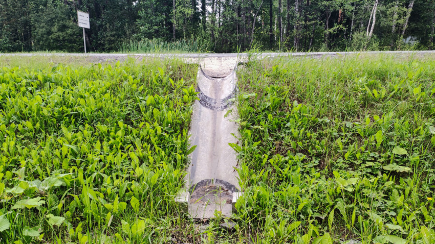 Бетонный водоотводящий лоток на склоне обочины