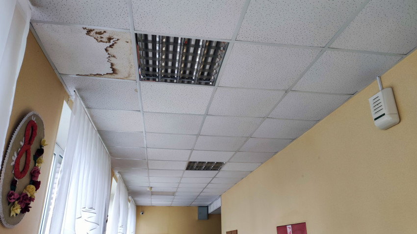 Подвесной потолок в коридоре с поврежденными панелями от влаги
