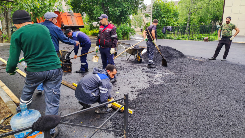 Рабочие укладывают асфальт на дворовой территории