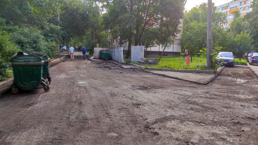 Двор жилого дома с ремонтируемым проездом и мусорными контейнерами