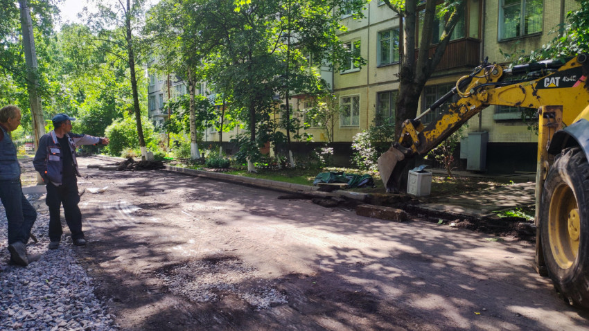 Рабочие и техника при ремонте дворовой дороги