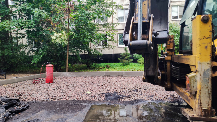 Строительная техника на фоне подготовленного основания из щебня