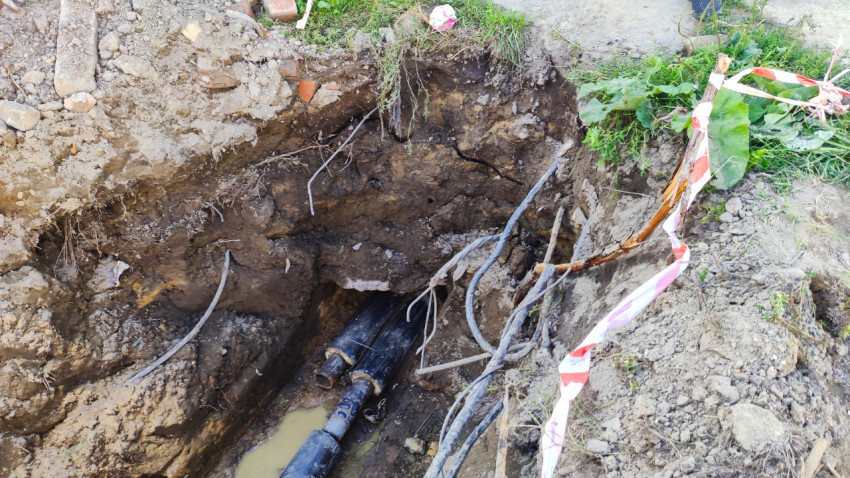 Траншея с проложенными кабелями и трубами