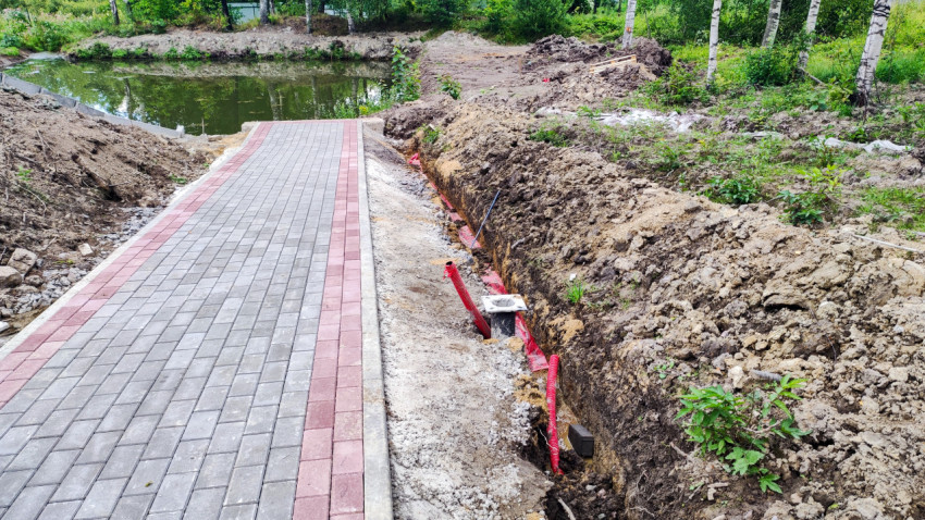 Кабельные коммуникации в траншее рядом с водоёмом