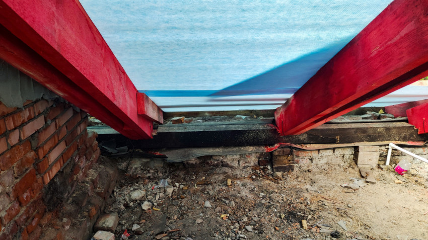 Красные балки крыши и кирпичная стена внутри здания