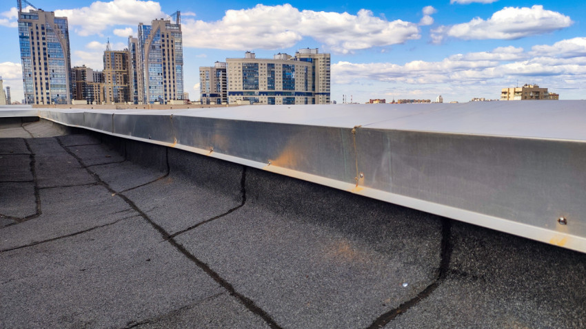 Металлическое покрытие парапета на крыше и городская застройка