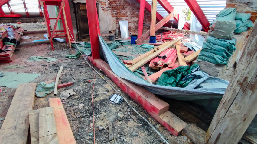 Строительные материалы и инструменты на полу чердака