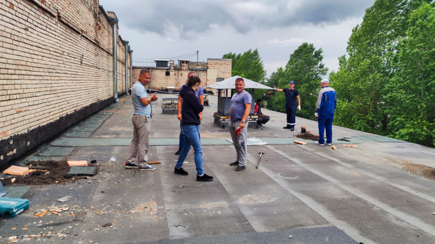 Рабочие на крыше жилого здания во время ремонта