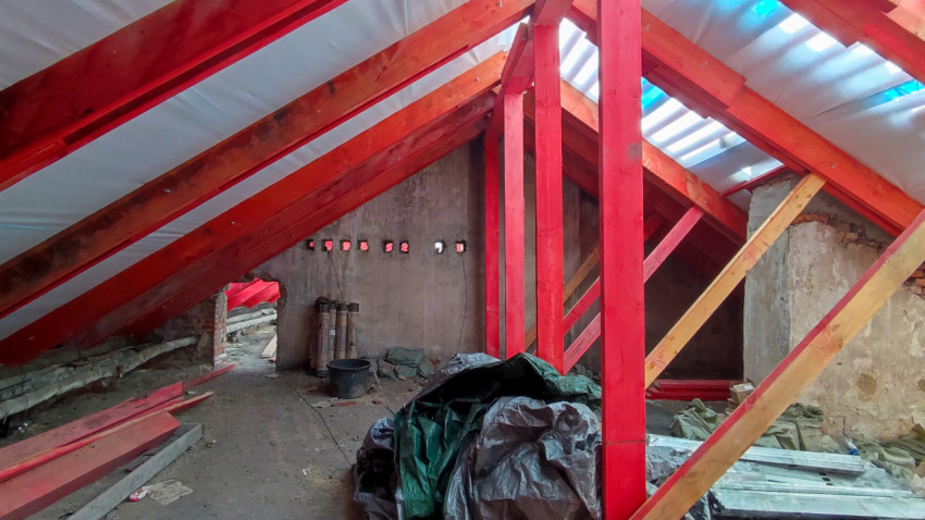 Чердак с деревянными стропилами и ремонтными материалами