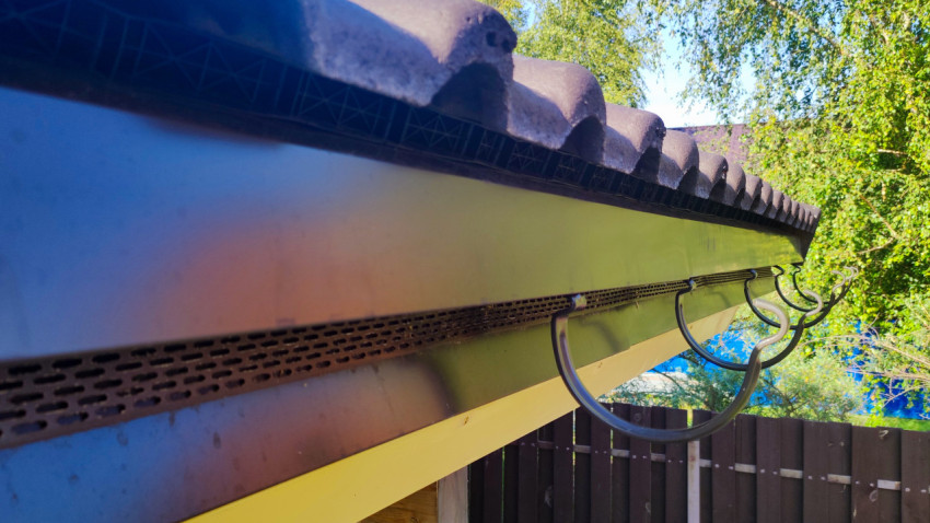 Установленные кронштейны водостока под свесом крыши