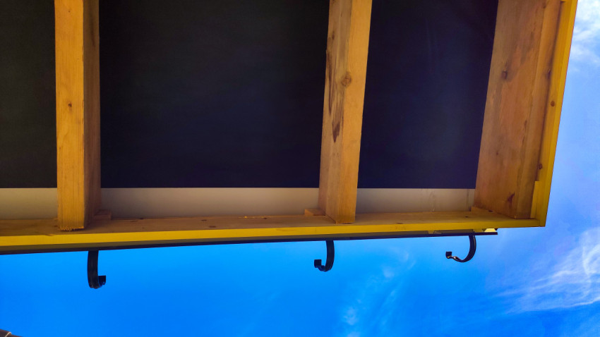 Вид снизу на кровлю с деревянными стропилами и кронштейнами под водосток