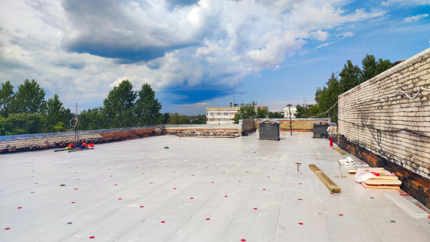 Кровля жилого дома с элементами ремонта и инструментами