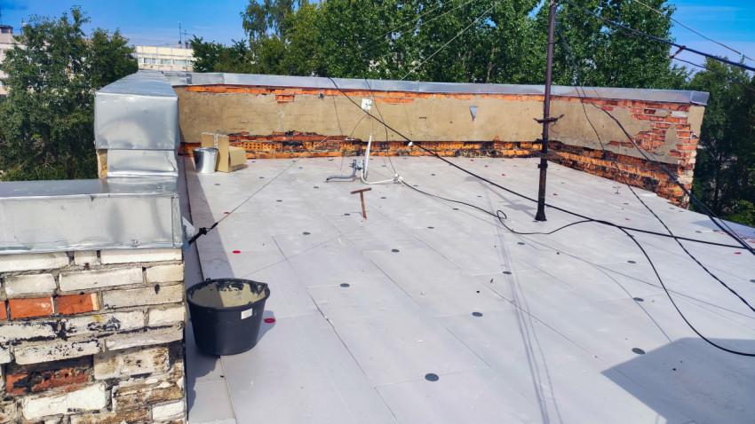 Крыша жилого дома с парапетом и кабелями