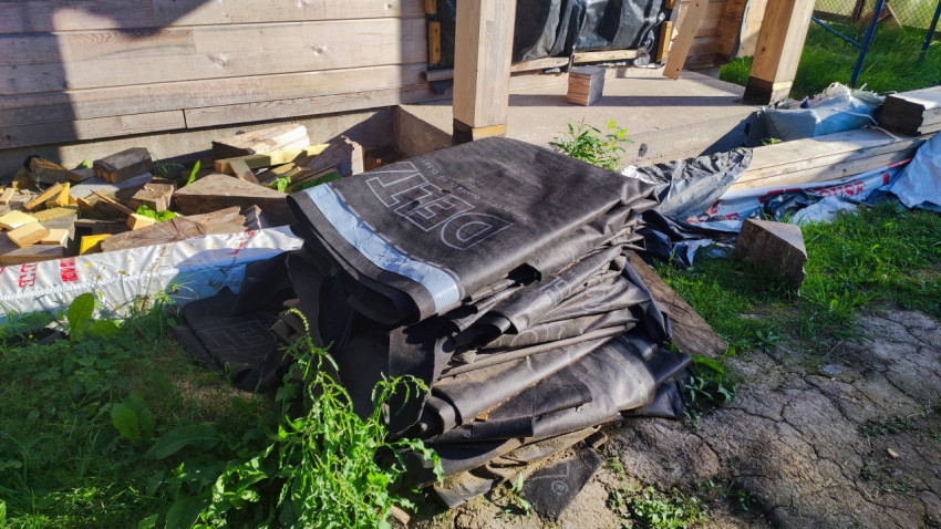 Складирование рулонов гидроизоляционного материала возле дома