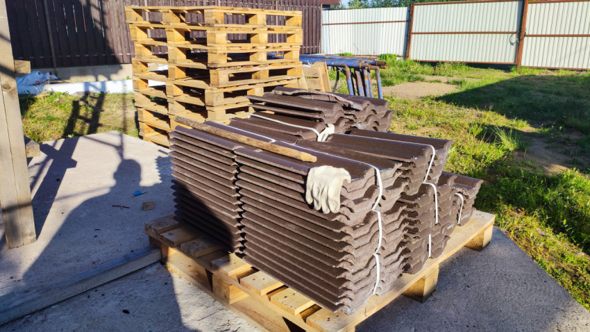 Складированные листы черепицы на строительной площадке