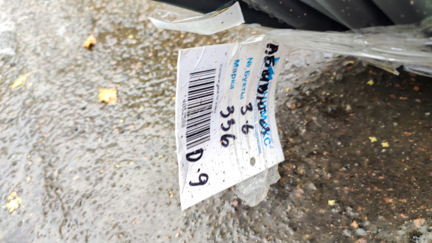 Бирка на бухте кабеля на мокром асфальте