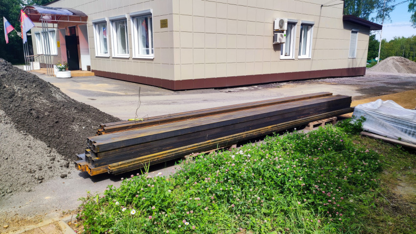 Строительные материалы и металлические балки возле административного здания