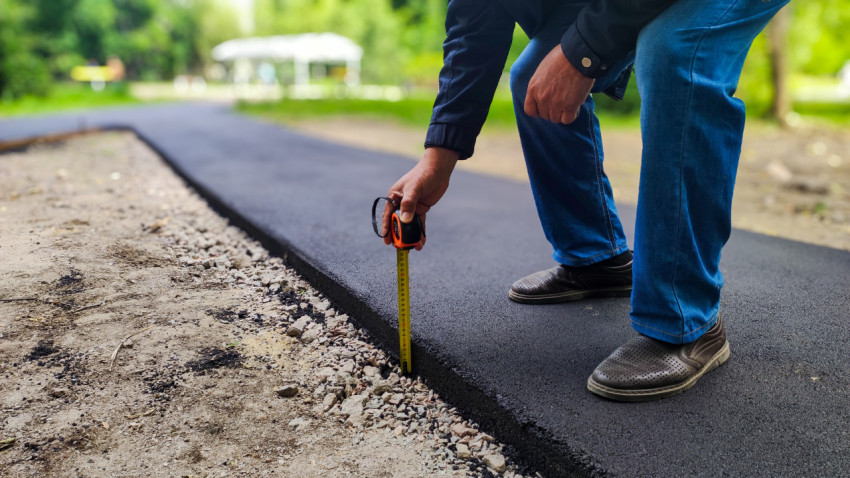 Измерение асфальтового покрытия на дорожке во дворе
