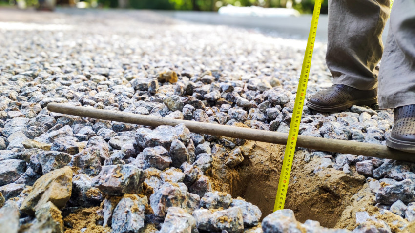 Измерение глубины щебня в основании дороги