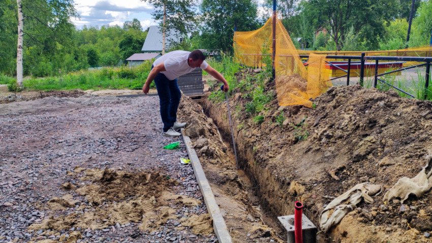 Замер глубины траншеи на строительной площадке