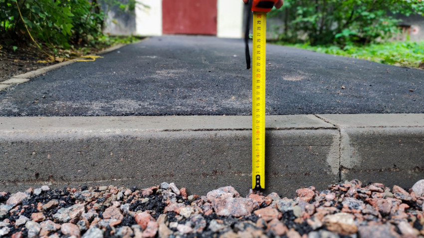 Крупный план замера высоты бордюра