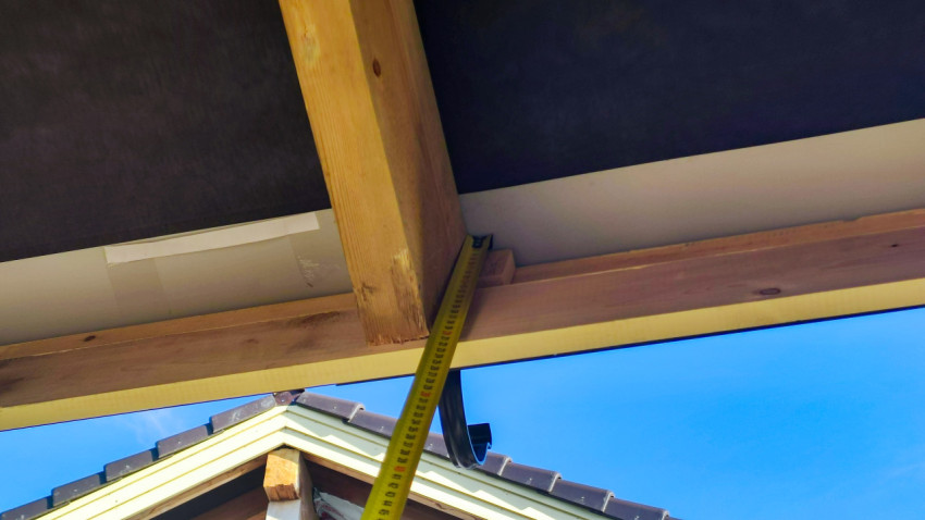 Замер расстояния под кровлей деревянного дома для установки водостока