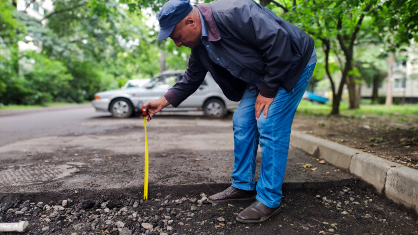 Измерение глубины слоя асфальта при ремонте