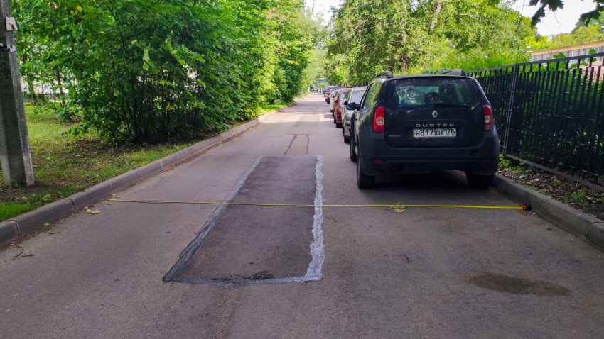 Замер ширины дороги рулеткой между бордюрами