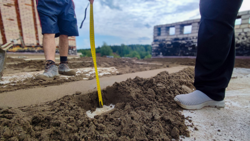 Измерение уровня цементной стяжки рулеткой