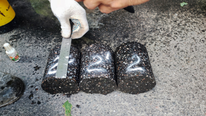 Керны асфальта и измерение специалистом на месте испытаний