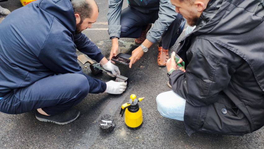 Специалисты проверяют образцы асфальта на месте бурения