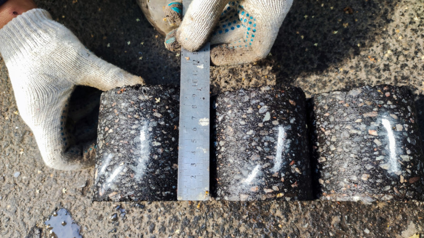 Замеры дорожных кернов специалистом в перчатках