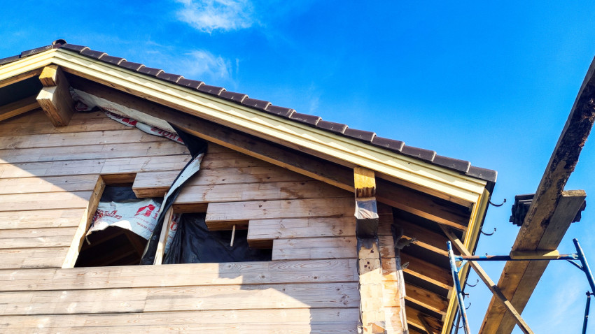 Фронтон деревянного дома с кровлей и подшивкой в процессе строительства