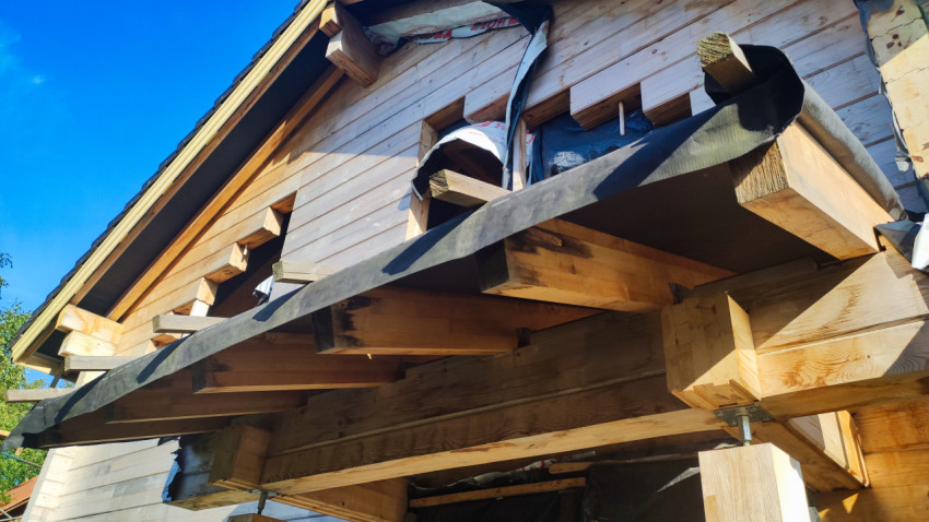 Деревянный фронтон дома с выступающими балками и подшивкой