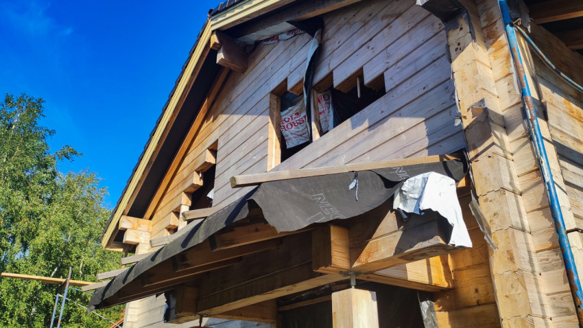 Фронтон деревянного дома с незавершенной подшивкой и оконными проемами