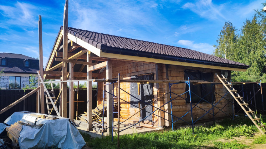Каркас и фасад деревянного дома в стадии строительства