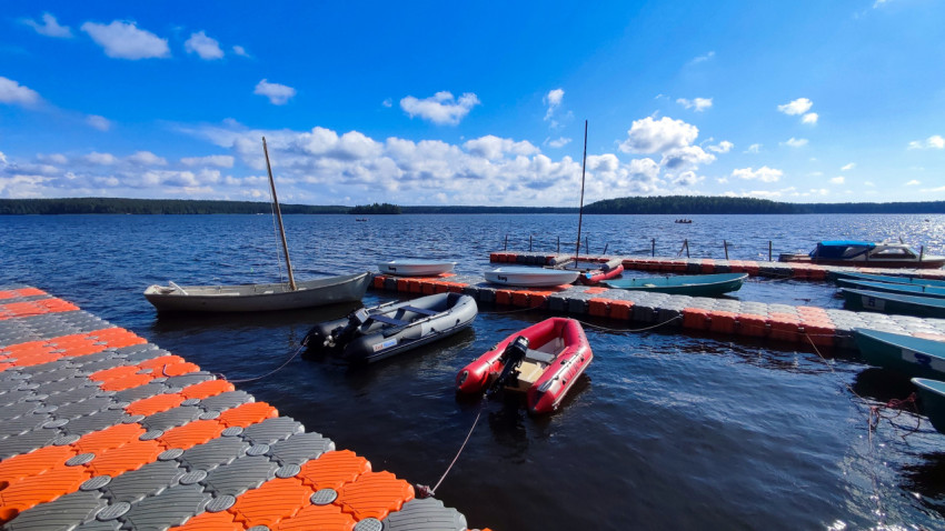 Причал с лодками и катамаранами на фоне озера