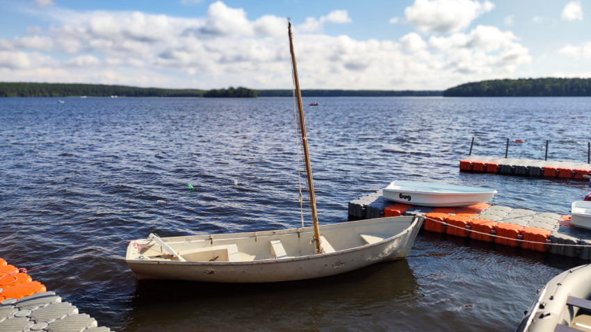 Деревянная лодка у понтона на озере