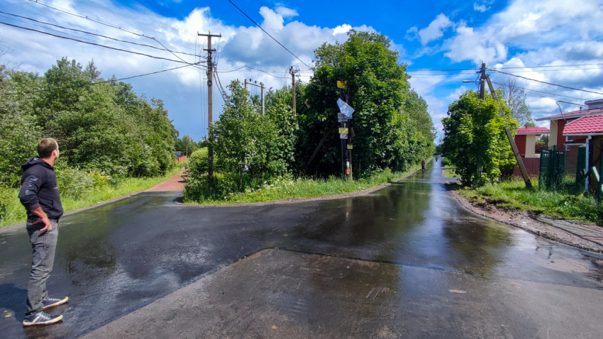 Перекрёсток сельских дорог с электропроводами и человеком на обочине