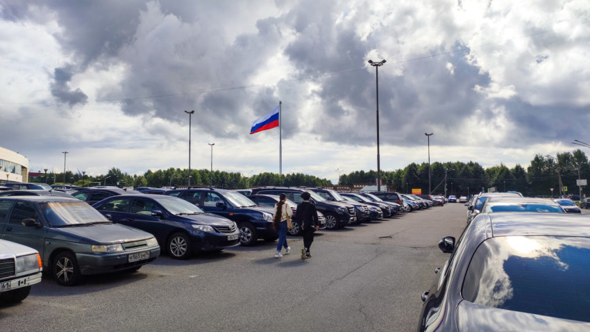 Автомобили на парковке под государственным флагом России