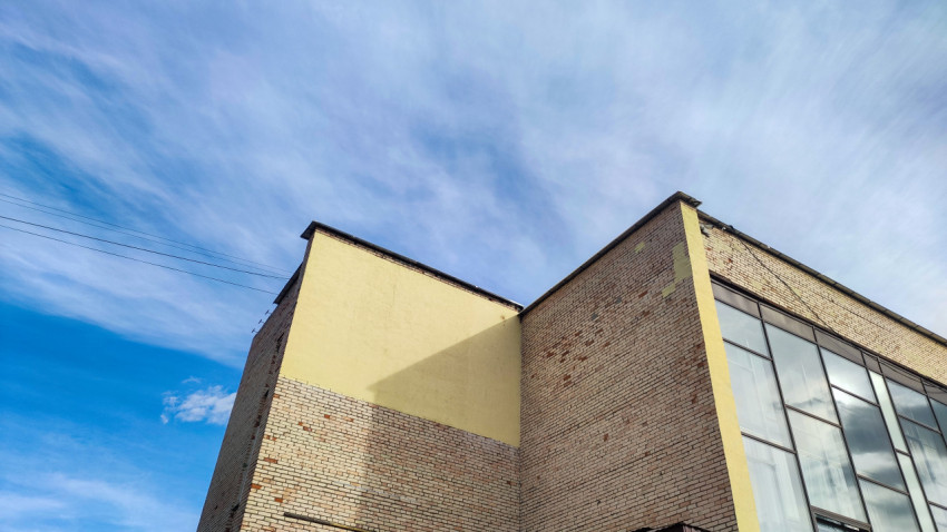 Стена здания с кирпичной кладкой и остеклением