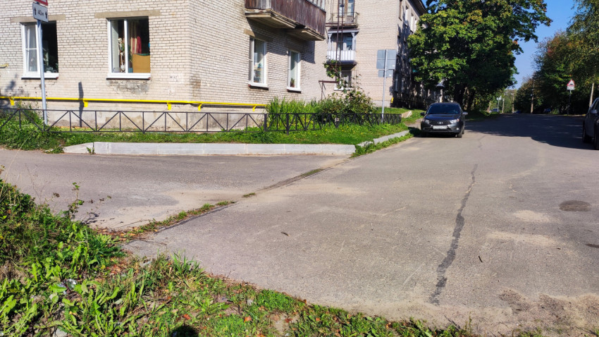 Угол жилого дома и выезд на улицу с бордюром