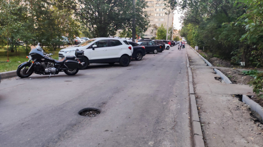 Парковка автомобилей и мотоцикла вдоль жилого дома