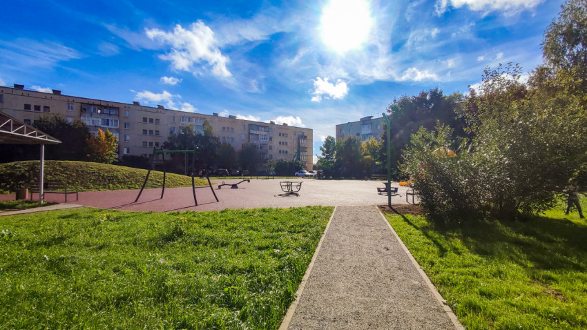 Детская площадка с качелями и прогулочной зоной после благоустройства